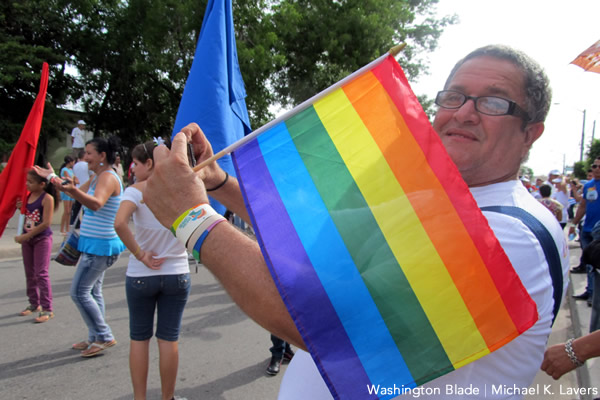 A man holding a rainbow flag prepares to take part in a march in Las Tunas, Cuba, on May 16, 2015, to commemorate the International Day Against Homophobia and Transphobia (Washington Blade photo by Michael K. Lavers)