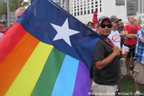Axel Rodríguez of Orlando, Fla., holds a Puerto Rican flag with rainbow colors on it during a memorial service on June 13, 2016, that paid tribute to the victims of the Pulse Nightclub massacre. (Washington Blade photo by Michael K. Lavers)