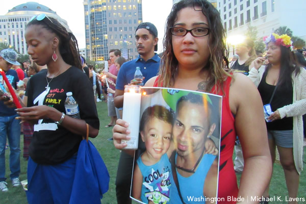 A woman with a picture of her friend who died inside the Pulse nightclub attends a memorial in Orlando, Fla., on June 13, 2016. (Washington Blade photo by Michael K. Lavers)