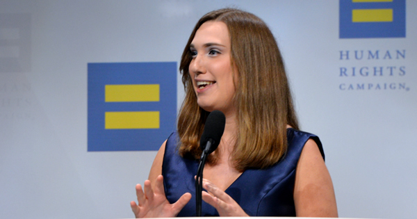 Sarah McBride speaking at an HRC event in a blue dress
